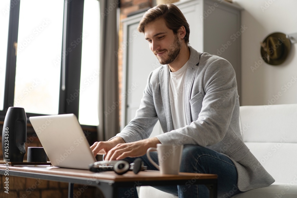 Businessman working with laptop from home sitting at table. Businessman working with laptop from home sitting at table.