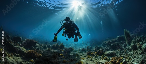 a diver with full scuba equipment performs in the deep blue sea