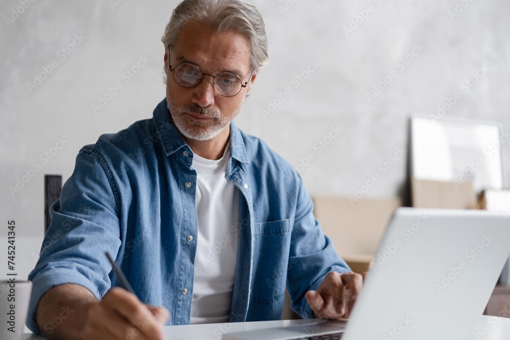 Middle-aged man working from home-office on laptop. Middle-aged man working from home-office on laptop.