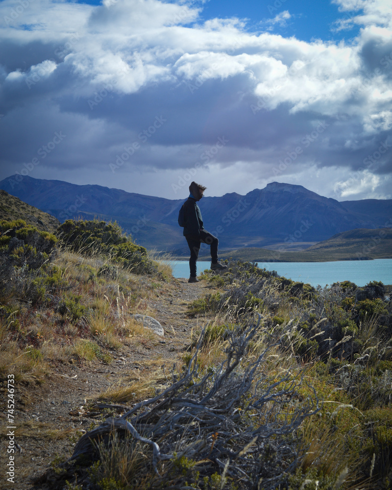 Hombre joven en diferentes paisajes, con montañas de fondo disfrutando de sus trekkings y senderos,  paisaje de lagos, montañas y colores