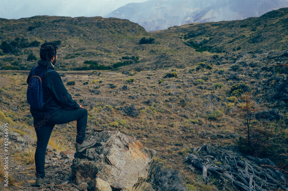 Hombre joven en diferentes paisajes, con montañas de fondo disfrutando de sus trekkings y senderos,  paisaje de lagos, montañas y colores