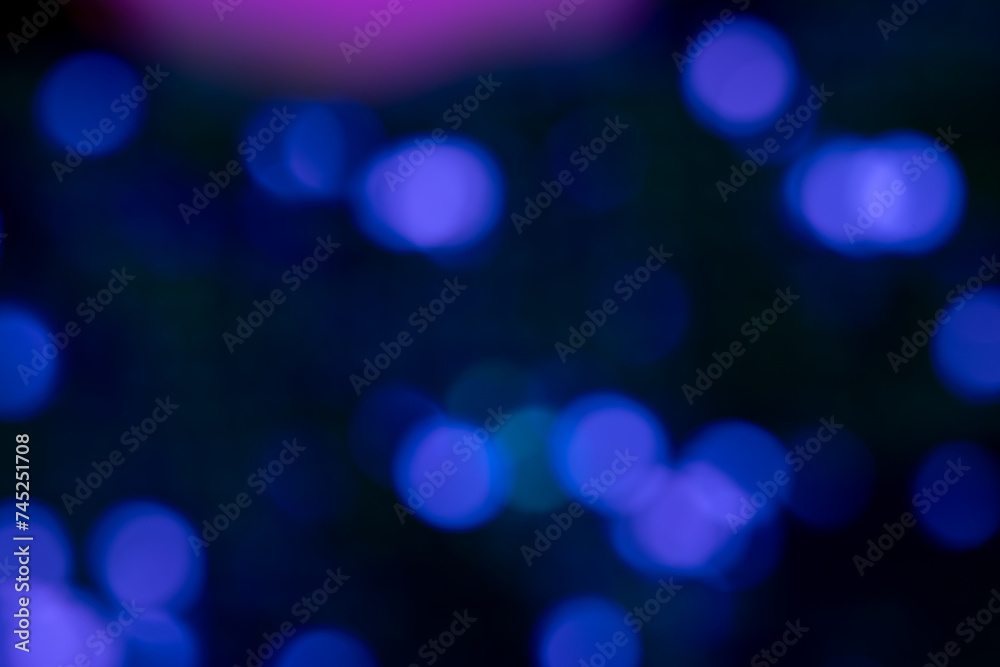 Soft blue circular bokeh lights floating on a dark background suitable for festive or technology-themed backgrounds. Soft blue circular bokeh lights floating on a dark background suitable for festive or technology-themed backgrounds.