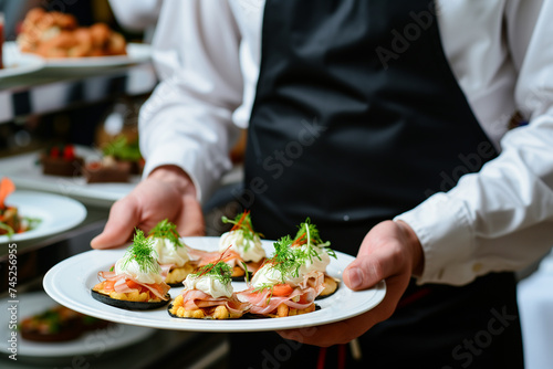 Elegant party appetizers: seafood and cheese canapes on a waiter's tray.