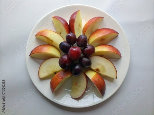 Plate of sliced apple and grapes