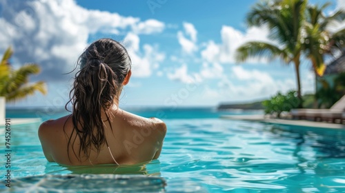 A woman enjoys a leisurely summer day lounging by a luxurious swimming pool