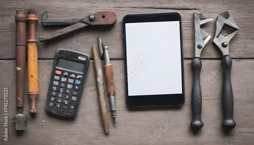 Stylish arrangment of old grungy working tools with smartphone, calculator, glasses and notepad