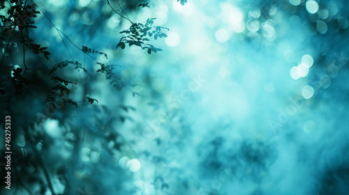 abstract background with bokeh defocused lights and tree branches. Soft ethereal blue bokeh, blurred into an abstract background of serene light