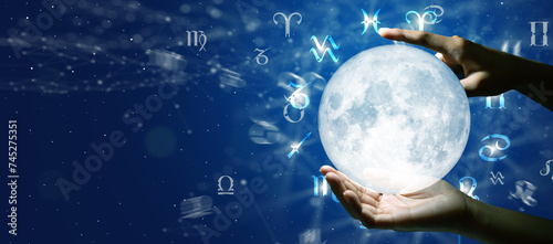 Astrological zodiac signs over the moon in hand. Knowledge of the stars in the sky. The power of the universe concept.