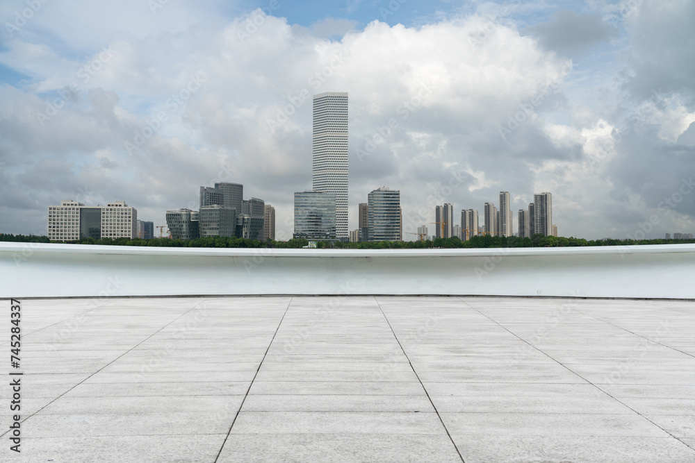 empty ground floor with modern cityscape and cloudy sky.
