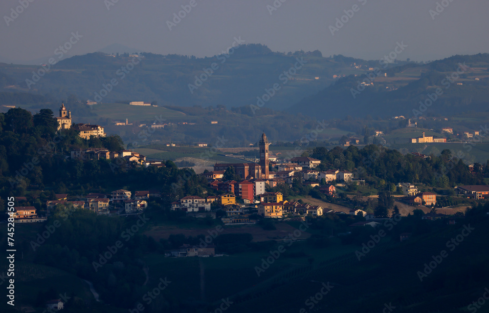 typical piedmontese landscape with small villages and vines in sunrise light