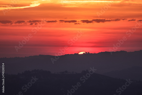 Fototapeta Naklejka Na Ścianę i Meble -  the sun rises behind a mountain range in Piedmont