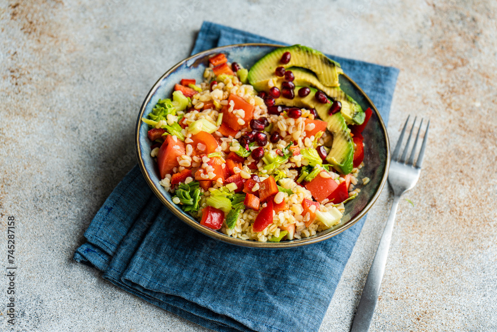 Close-up of a bulgur wheat, avocado, tomato, red pepper and pomegranate salad Close-up of a bulgur wheat, avocado, tomato, red pepper and pomegranate salad