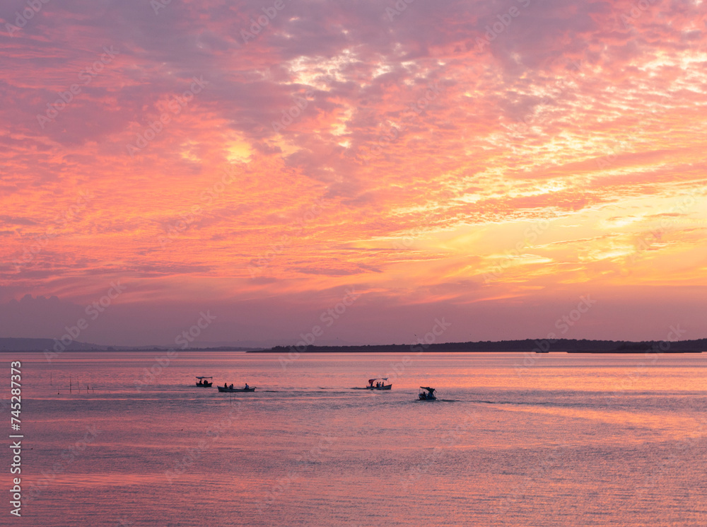 Pinky sunset at a lake and boats