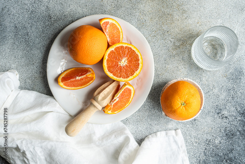 Overhead view of fresh oranges being juiced to make freshly squeezed orange juice photo