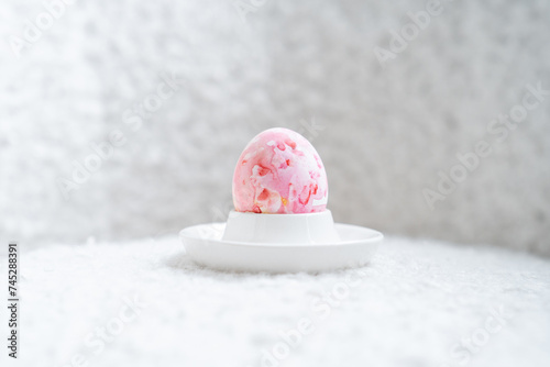Close-up of a pink painted Easter Egg in an egg cup on a table photo