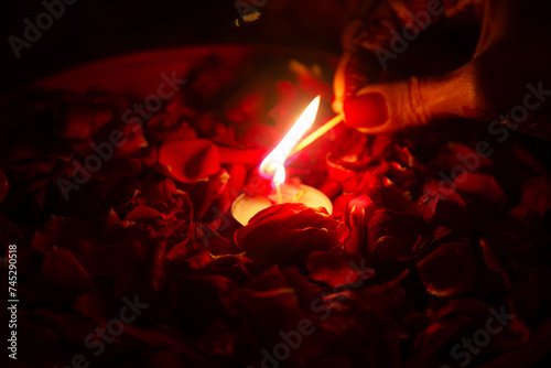 Close-up of a woman lighting a tea light as part of a Wedding ritual, India photo
