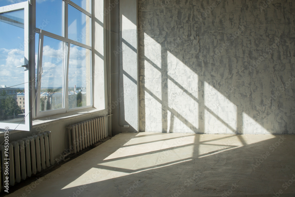 Obraz premium Drawing a shadow from a window on a concrete wall and floor
