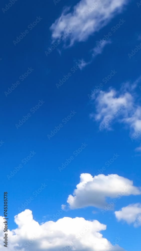 Light airy clouds moving along the blue sky. Beautiful white fluffy clouds against bright sky. Timelapse. Vertical video. Light airy clouds moving along the blue sky. Beautiful white fluffy clouds against bright sky. Timelapse. Vertical video.