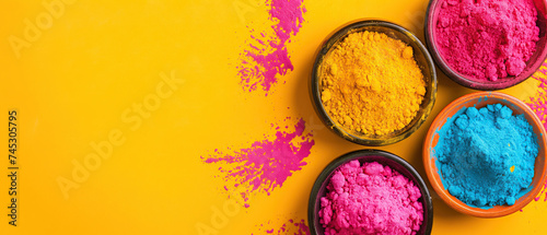 Holi festival background with colorful powder in bowls, wide yellow banner with copy space photo