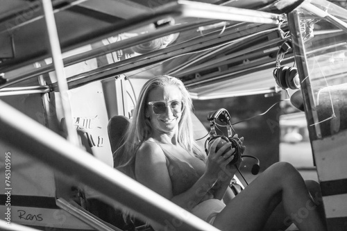 mujer rubia pilotea avioneta en blanco y negro photo