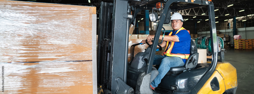 Warehouse worker workers with forklift in a warehouse. Use forklift operator moves packages. Concept industrial and commercial.