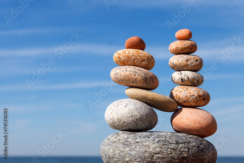 Canvas Print Two pyramids of colored balanced rocks on a background of blue sky