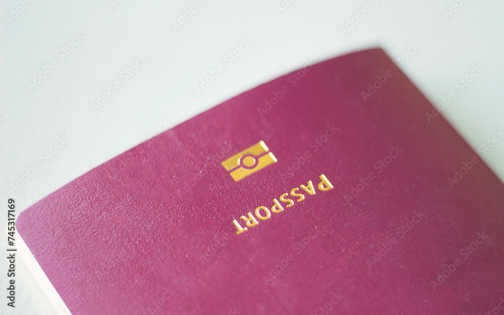 Close up of burgundy passport on grey background. Immigration and travel concept Close up of burgundy passport on grey background. Immigration and travel concept