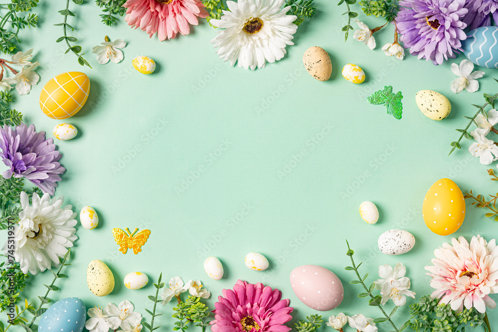 Happy Easter composition for easter design. Elegant Easter eggs and spring flowers on mint background. Flat lay, top view, copy space.