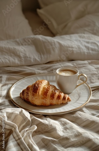 breakfast croissant and coffee on tray over bed