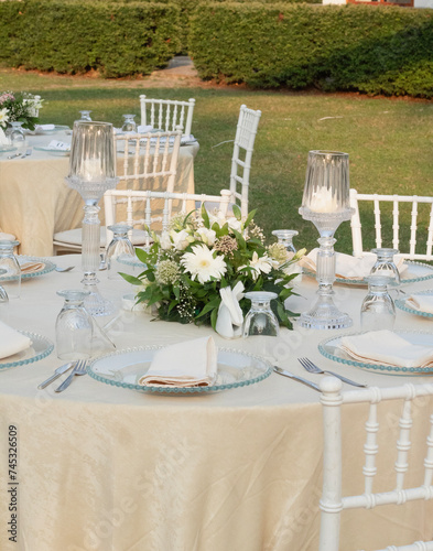 Wedding table decoration with fresh colorful flowers, plates and candles