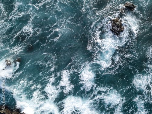 Fototapeta Naklejka Na Ścianę i Meble -  View from drone of Atlantic Ocean waves meeting with sharp underwater rocks. Sea waves crash on rocks with foam, south of Tenerife, Canary Islands