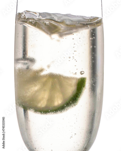 ein freigestelltes erfrischendes kühles Sektglas mit Luftblasen und Zitrone im Glas auf freigestelltem Hintergrund