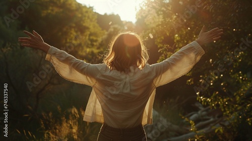 woman standing in sunlight outdoors with arms raised, embracing the beauty of nature and freedom