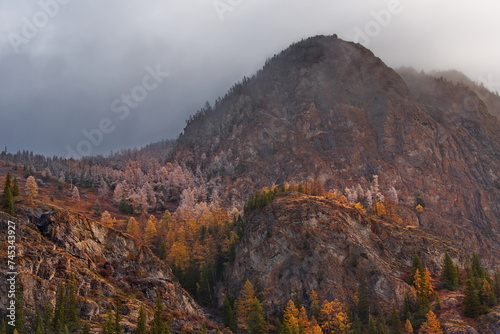 Russia. Mountain Altai. Fog turning into snow clouds around mountain peaks in the Chulyshman River valley in the south of Lake Teletskoye.