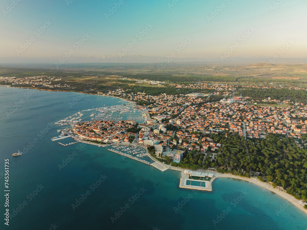 Biograd na Moru, marina aerial view with beach, sailing boats and luxury yachts in port. Historic Old Town architecture, summer clear sky and blue waters of Adriatic Sea in Dalmatia region of Croatia