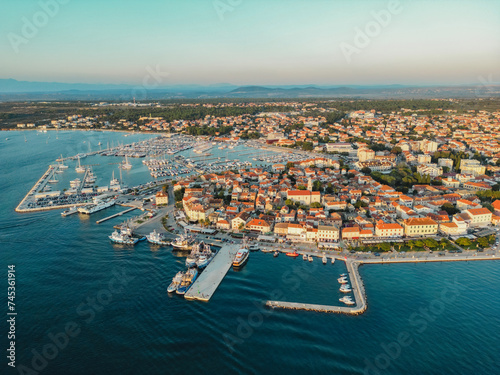 Biograd na Moru, marina aerial view, port with sailing boats and luxury yachts in sunlight. Summer landscape with Old Town houses and blue waters of Adriatic Sea coast, Dalmatia region in Croatia photo
