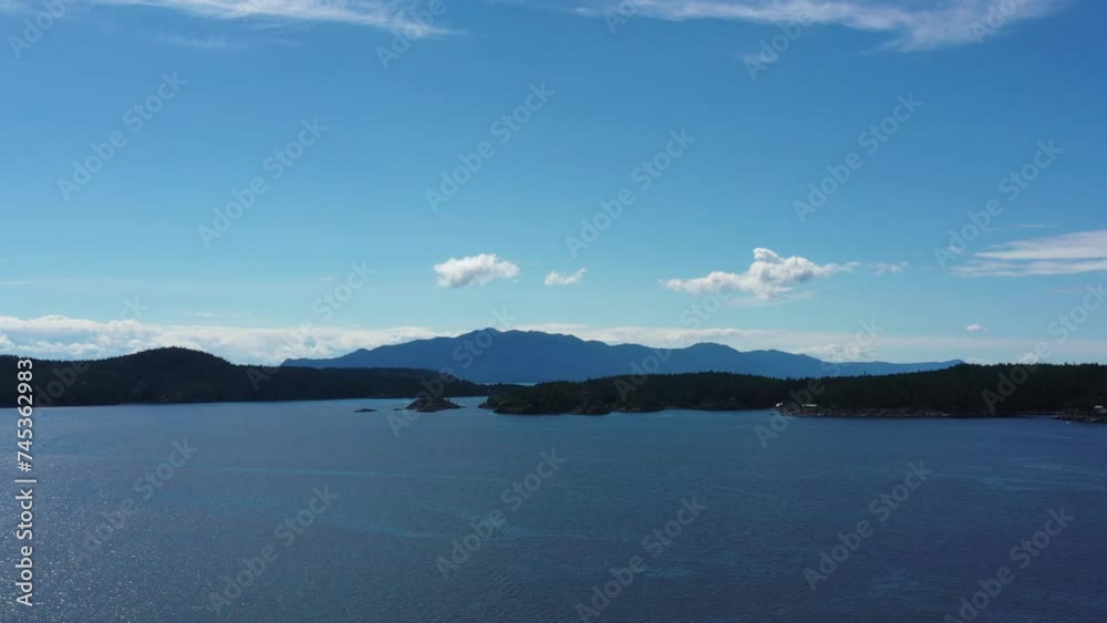 Establishing aerial shot of ocean beach with trees and mountains in slow motion at summer day in Vancouver, Canada, North America. Day time on September 2023. Still camera. ProRes 422 HQ. Establishing aerial shot of ocean beach with trees and mountains in slow motion at summer day in Vancouver, Canada, North America. Day time on September 2023. Still camera. ProRes 422 HQ.