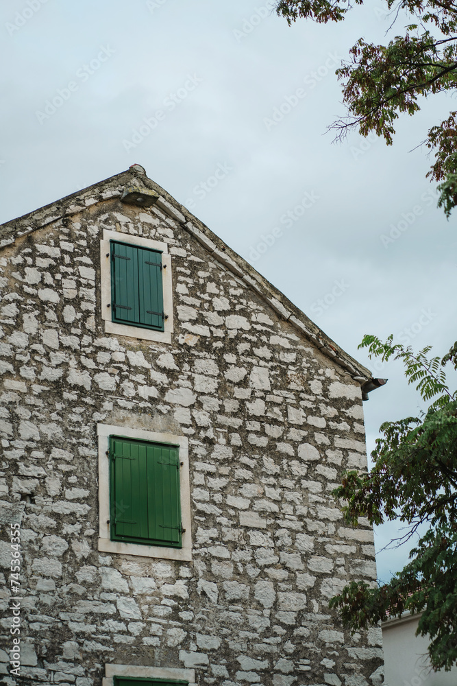 Old stone house and windows with closed green wooden shutters in Old Town, Biograd na Moru of Croatia