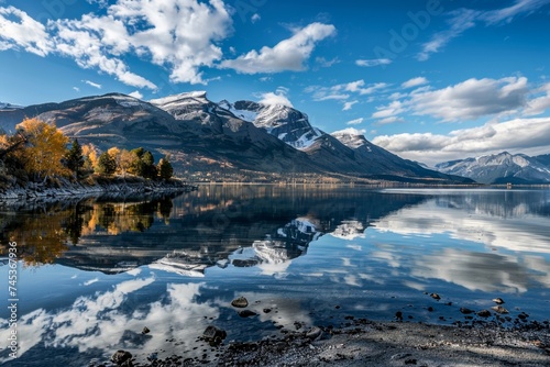 A breathtaking calm lake reflects surrounding mountains under a crisp blue sky