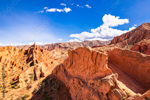 Aerial view to beautiful landscape of Skazka canyon. Rocks Fairy Tale famous destination in Kyrgyzstan. Rock like great wall of china and Rainbow Mountains of Danxia on Issyk-Kul lake. Central Asia