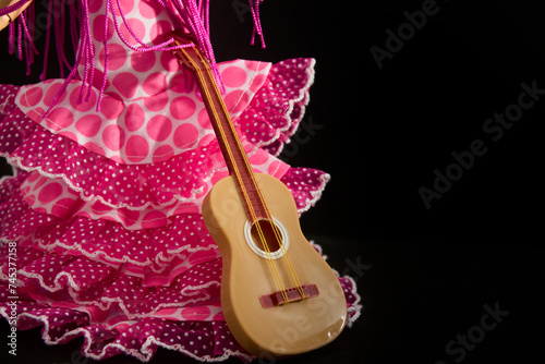 Faralaes costume for a flamenco dancer with a guitar. Black background with copy space photo