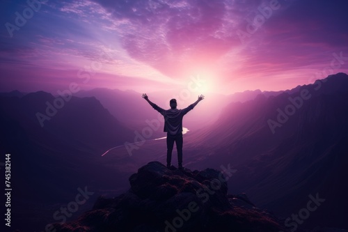 Man standing on top of a mountain with arms outstretched.