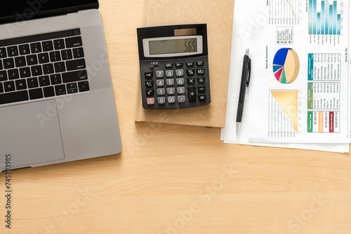 Business desk workplace with laptop, calculator and sales report top view copy spce photo