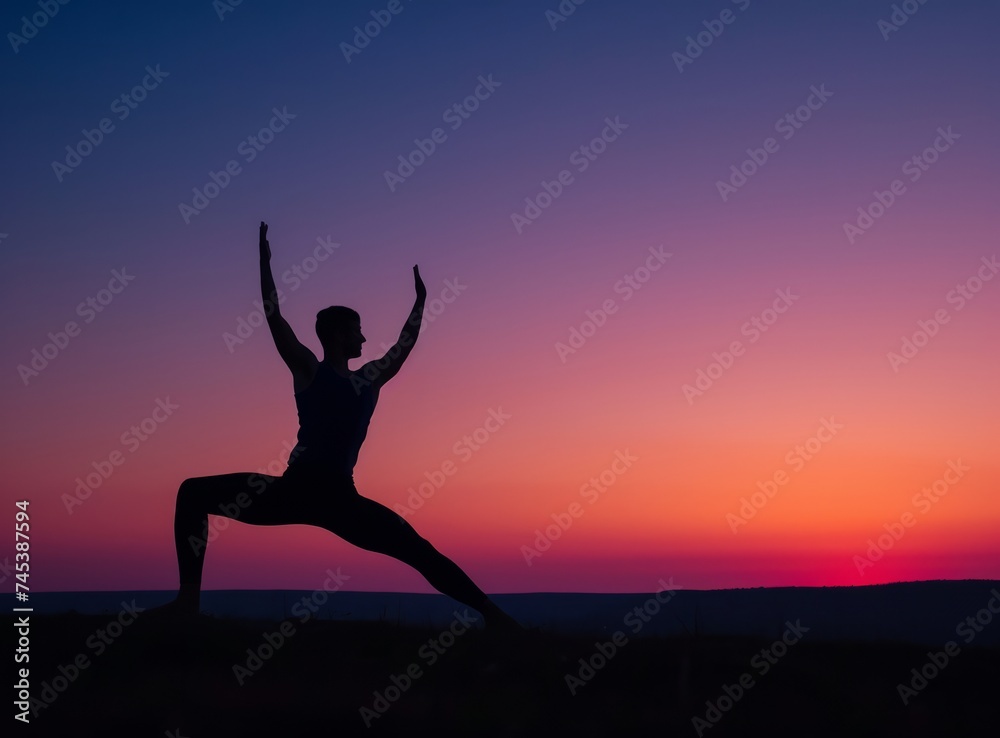 Silhouette of a man in a yoga pose against a sunset background. Beautiful sky.