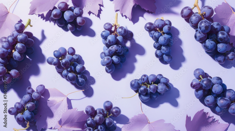 a bunch of grapes sitting on top of a table next to a bunch of leaves on a white tablecloth. a bunch of grapes sitting on top of a table next to a bunch of leaves on a white tablecloth.