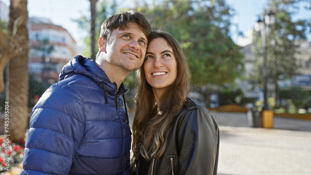 Loving couple embracing outdoors in a city park, showcasing a close relationship between a man and woman in a casual urban setting. Loving couple embracing outdoors in a city park, showcasing a close relationship between a man and woman in a casual urban setting.