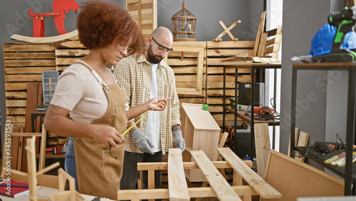 Two professional carpenters, partners in crime at woodwork, baldly measuring a sturdy wood plank in a bustling carpenter's workshop amid industry hustle photo