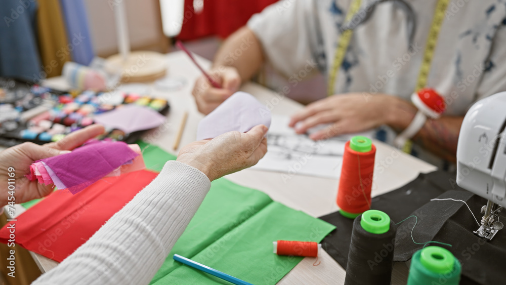 Two tailors working with fabrics and sewing accessories in a tailor shop, crafting custom garments. Two tailors working with fabrics and sewing accessories in a tailor shop, crafting custom garments.