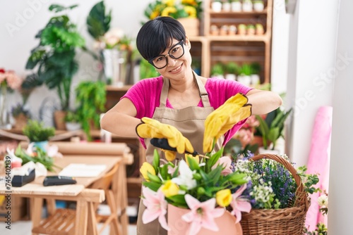 Middle age chinese woman florist cutting plants at flower shop