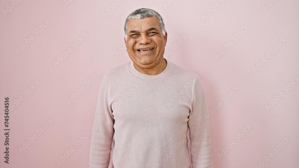 Smiling middle-aged man with grey hair posing against a pink wall isolated background Smiling middle-aged man with grey hair posing against a pink wall isolated background